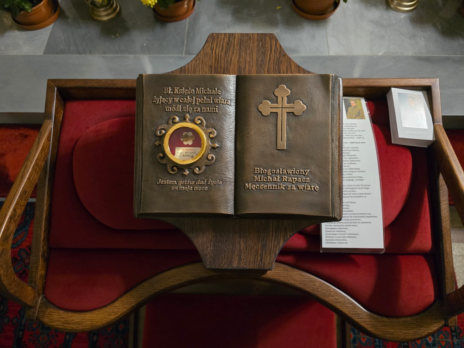 Relikwie błogosławionego księdza Michała Rapacza umieszczone w relikwiarzu w kształcie księgi Pisma Świętego na klęczniku w sanktuarium w Płokach.